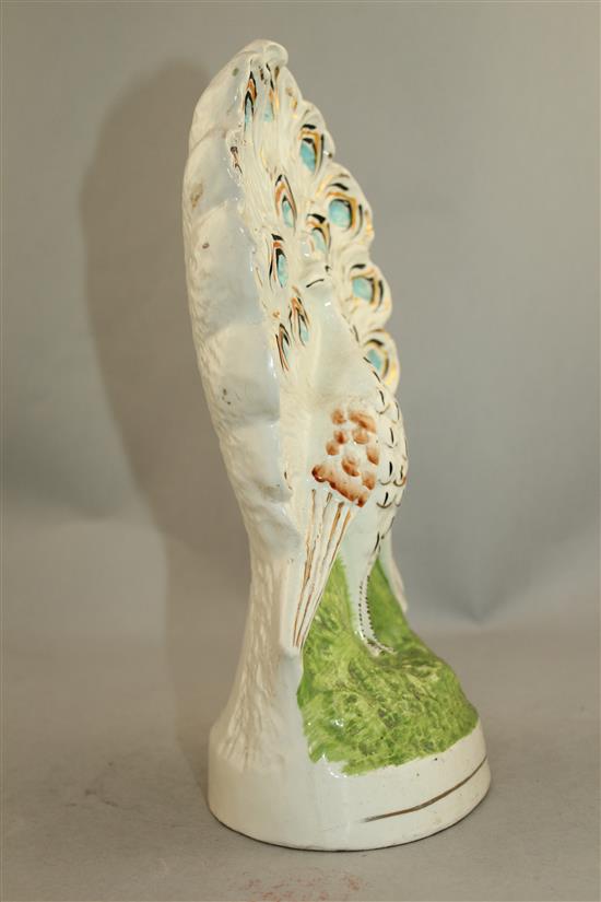 An unusual Staffordshire pottery flatback peacock figure, mid 19th century, 29.5cm.